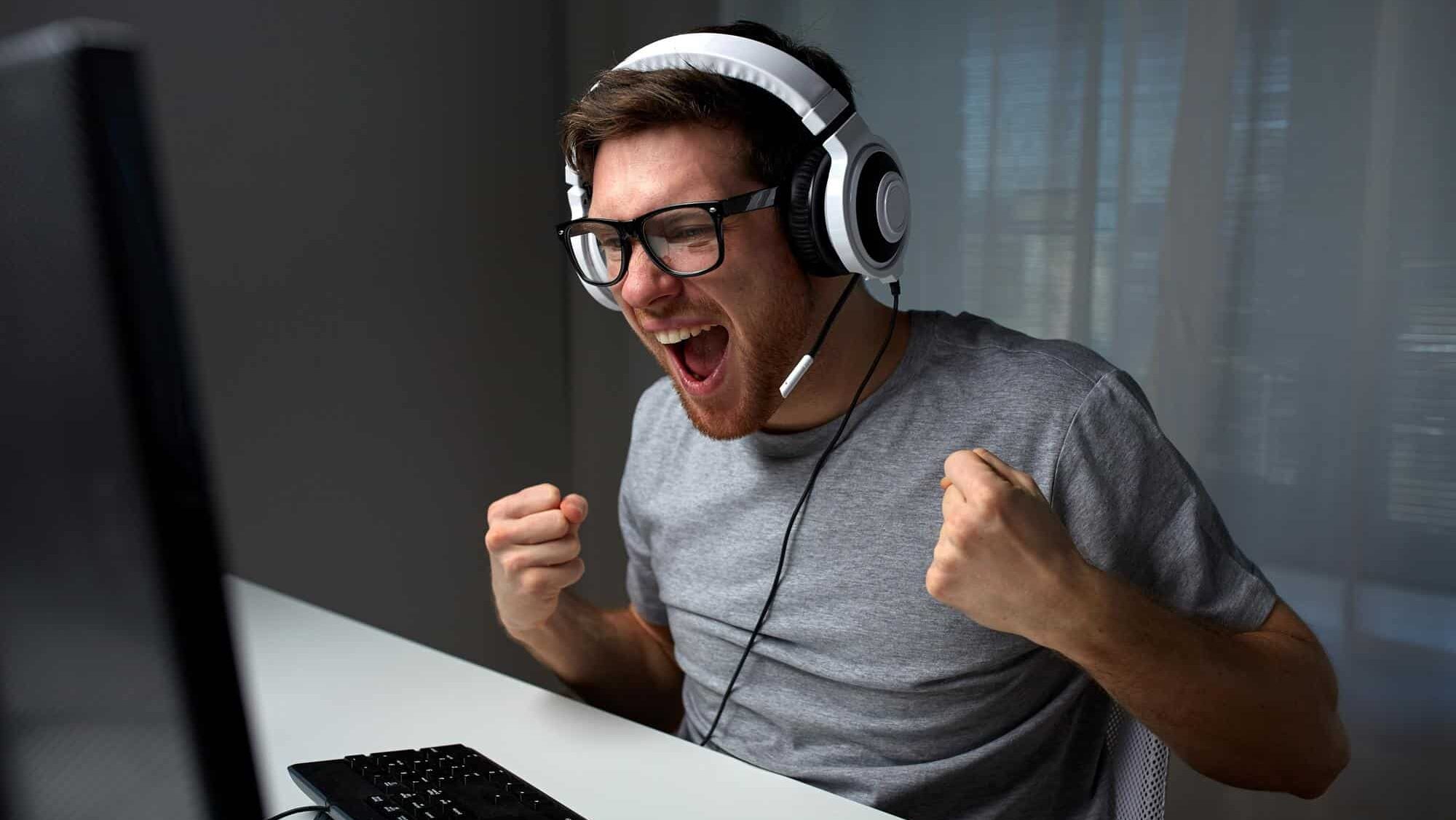 Mann sitzt mit Kopfhörern vor Computer
