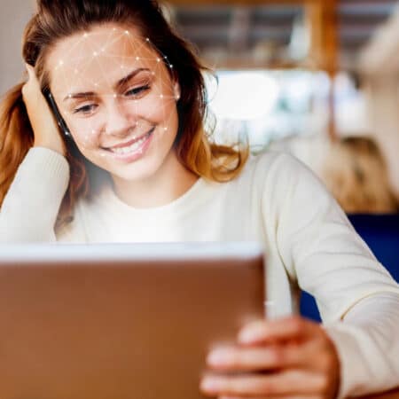 Junge Frau sitzt vor Laptop und betreibt Online-Marketing